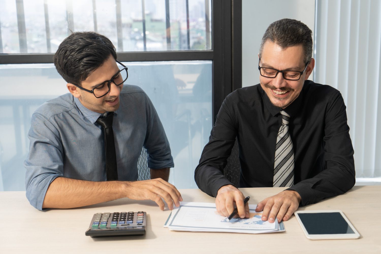 Business owners reviewing financial reports with an accountant in Delta